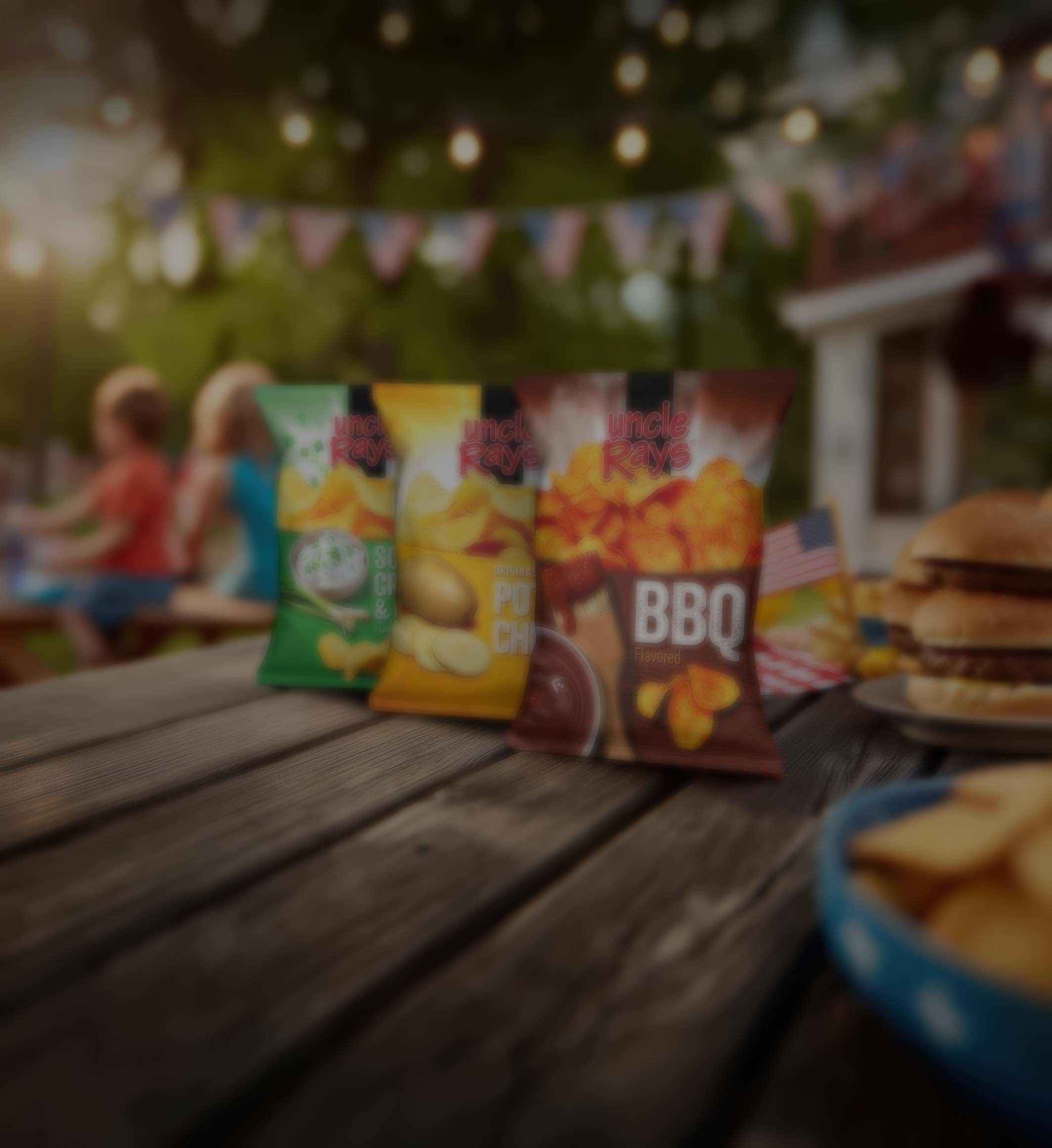 Three bags of chips on a wooden table with a blurred background of people and food.