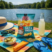 Picnic setup with Uncle Ray's Salt & Vinegar chips, lemonade, and snacks by a lake.